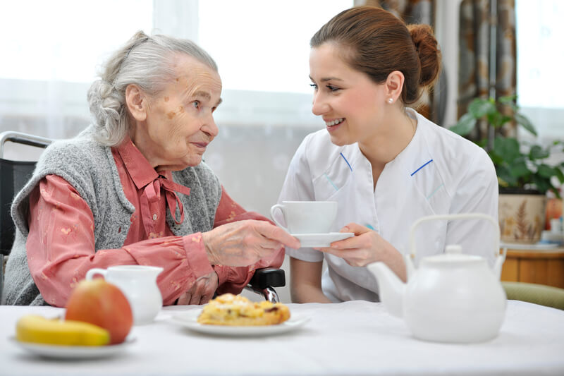 Woman having a cup of tea in aged care