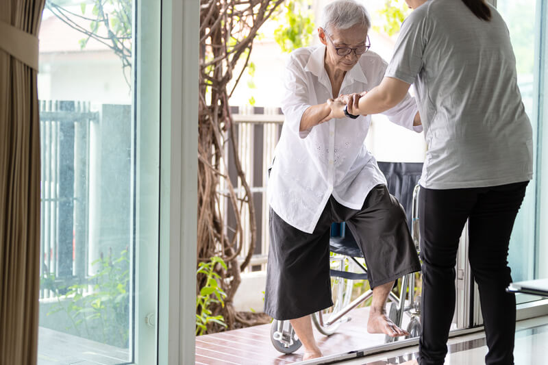 Support worker helping a client through a doorway