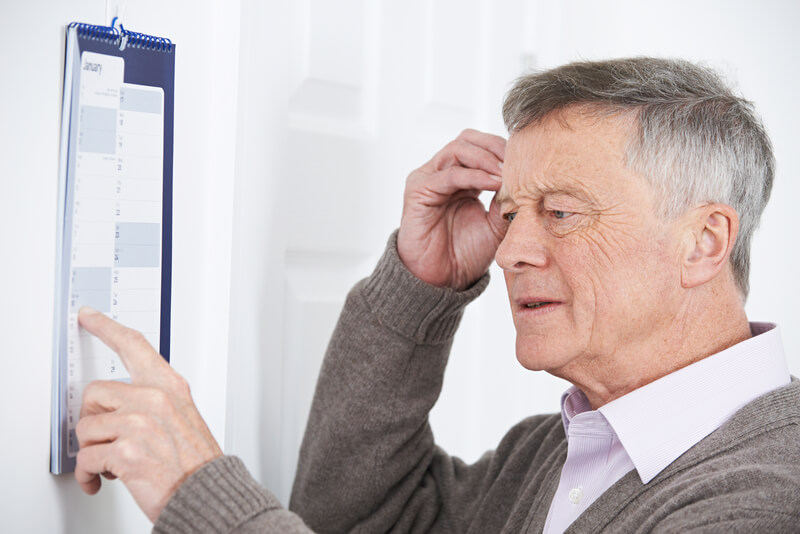 Older man looking at a calendar